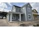 New two-story home featuring gray siding, white trim, a covered porch, and a black shingle roof at 717 Blueway Ave, Summerville, SC 29486