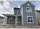 New two-story home featuring gray siding, white trim, a covered porch, and bright windows at 717 Blueway Ave, Summerville, SC 29486