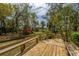 Inviting back deck featuring wooden benches, offering a relaxing outdoor space surrounded by mature trees and greenery at 755 Jumbo Ln, Edisto Island, SC 29438