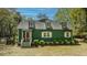Two-story home with green siding, a gray shingled roof, and white-trimmed windows and shutters at 755 Jumbo Ln, Edisto Island, SC 29438