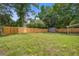 Fenced backyard featuring green grass and mature trees at 780 Corral Dr, Charleston, SC 29414