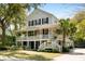 Charming two-story home with a welcoming porch, lush landscaping, and classic coastal architecture at 825 Marsh Grove Ave, Mount Pleasant, SC 29464