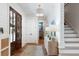 Bright foyer with wood floors, a statement light fixture, and staircase at 825 Marsh Grove Ave, Mount Pleasant, SC 29464
