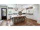Spacious kitchen featuring white cabinets, brick backsplash, a large center island, and modern lighting at 825 Marsh Grove Ave, Mount Pleasant, SC 29464