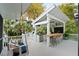 Outdoor kitchen with bar seating, built-in grill, and a swing bed on the covered porch at 825 Marsh Grove Ave, Mount Pleasant, SC 29464
