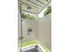 Outdoor shower with white shiplap walls, stone pebble floor, and view of the palm trees at 825 Marsh Grove Ave, Mount Pleasant, SC 29464