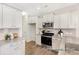 Well-lit kitchen boasts white cabinets, modern appliances, a tiled backsplash, and durable flooring at 1008 Drakeford St # 4P, Saint George, SC 29477