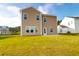 Exterior of tan home in backyard with a green lawn, ideal for Gathering fun and entertaining at 1017 Marsh Harrier Dr # Cc3-3-3, Ravenel, SC 29470