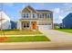 Charming two-story home boasts a well-manicured lawn, two-car garage and inviting orange front door at 1017 Marsh Harrier Dr # Cc3-3-3, Ravenel, SC 29470