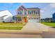 Beautiful two-story home features a manicured lawn, two-car garage and a cheerful orange front door at 1017 Marsh Harrier Dr # Cc3-3-3, Ravenel, SC 29470