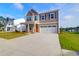 Inviting two-story home with a manicured lawn, two-car garage, and a cheerful orange front door at 1017 Marsh Harrier Dr # Cc3-3-3, Ravenel, SC 29470