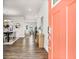 Bright foyer showcasing hardwood floors, with a view to dining and living areas, through a vibrant orange door at 1017 Marsh Harrier Dr # Cc3-3-3, Ravenel, SC 29470