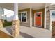 Covered front porch with white pillars, brick accents, and a bright orange door for a cheerful welcome at 1017 Marsh Harrier Dr # Cc3-3-3, Ravenel, SC 29470