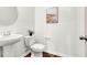 Powder room features pedestal sink, decorative painting, wood-look floors, and neutral color palette at 1017 Marsh Harrier Dr # Cc3-3-3, Ravenel, SC 29470