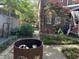 Charming backyard with a rusted fire pit and a brick-paved pathway, surrounded by lush greenery and mature trees at 1026 Stono River Dr, Charleston, SC 29412