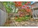 Beautiful backyard features a brick patio, lush landscaping, mature trees, and wooden fencing perfect for outdoor relaxation at 1026 Stono River Dr, Charleston, SC 29412