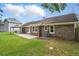 Brick home features a well-kept backyard with lush grass and a charming patio area with cover at 106 Ruffin Rd, Summerville, SC 29486