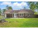 View of a brick home's backyard with a patio, showing the exterior and lawn in natural sunlight at 106 Ruffin Rd, Summerville, SC 29486