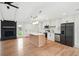 Open concept living room and kitchen with white cabinets, stainless appliances, kitchen island and a fireplace at 106 Ruffin Rd, Summerville, SC 29486