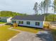 An eye-level exterior view of a charming white home, showcasing its well-manicured lawn at 117 Dotson St, Harleyville, SC 29448
