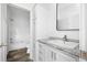 The bright bathroom features a modern vanity and sink, along with built-in shelving and a separate shower and toilet area at 117 Dotson St, Harleyville, SC 29448