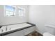 Modern bathroom featuring a tub and shower, and natural light from large windows at 117 Dotson St, Harleyville, SC 29448