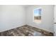 A minimalist bedroom with luxury vinyl flooring and a window creates a bright and calming space to promote rest and relaxation at 117 Dotson St, Harleyville, SC 29448