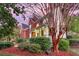 Side view of a red brick house featuring a covered front porch, mature trees, and lush landscaping at 1185 Out Of Bounds Dr, Summerville, SC 29485