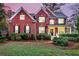 Charming red brick home featuring well-maintained landscaping, black shutters, and a welcoming front porch at 1185 Out Of Bounds Dr, Summerville, SC 29485