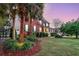 Side view of a brick home featuring mature landscaping, palm trees, and a charming front porch at 1185 Out Of Bounds Dr, Summerville, SC 29485