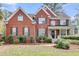 Charming red brick home featuring well-maintained landscaping, black shutters, and a welcoming front porch at 1185 Out Of Bounds Dr, Summerville, SC 29485