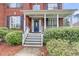 Close-up of a charming front porch with a black front door, white columns, and well-manicured landscaping at 1185 Out Of Bounds Dr, Summerville, SC 29485
