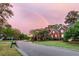 Street view of red brick houses, mature trees, green lawns, and a beautiful rainbow in the background at 1185 Out Of Bounds Dr, Summerville, SC 29485