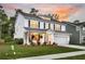 Beautiful two-story home with white siding, blue shutters, and an inviting front porch at sunset at 119 Loon Dr, Summerville, SC 29483