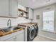 Well-organized laundry room with wood countertops, gray cabinetry, a sink, and modern washer/dryer set at 119 Loon Dr, Summerville, SC 29483