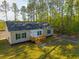 A charming single-story home boasting a lovely porch and a well-maintained lawn surrounded by trees at 121 Dotson St, Harleyville, SC 29448