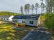 A charming single-story home featuring a cozy porch and well-manicured lawn with tall trees at 121 Dotson St, Harleyville, SC 29448