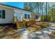 View of a cozy home featuring a charming front porch and green lawn bordered by a lush, wooded area at 121 Dotson St, Harleyville, SC 29448