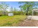 Expansive backyard featuring a storage shed, mature trees, and a covered patio, perfect for outdoor enjoyment at 1215 Redeemer Dr, Hanahan, SC 29410