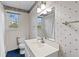 Bright bathroom features a large mirror, vanity with a white countertop, and patterned wallpaper at 1215 Redeemer Dr, Hanahan, SC 29410