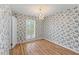 Cozy bedroom features hardwood floors, charming wallpaper and a bright light fixture at 1215 Redeemer Dr, Hanahan, SC 29410