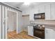 Galley kitchen features a white oven and upper cabinets, and a ceiling fan at 1215 Redeemer Dr, Hanahan, SC 29410