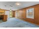 Spacious living room with paneled walls, blue carpet, and natural light from the windows and sliding glass door at 1215 Redeemer Dr, Hanahan, SC 29410