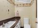 Bathroom featuring a sink, toilet, and palm tree wallpaper border at 1318 Foster St, Charleston, SC 29407