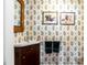 Charming bathroom with paisley wallpaper, wood vanity, framed art, and classic fixtures at 15 N Adgers Wharf, Charleston, SC 29401