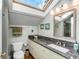 Bright bathroom with a skylight, granite countertop, and white cabinetry, creating a refreshing and elegant space at 15 N Adgers Wharf, Charleston, SC 29401