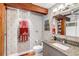 Updated bathroom with granite countertop, heated towel rack, rustic wood beam, and decorative wallpaper at 15 N Adgers Wharf, Charleston, SC 29401