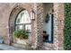 Charming brick exterior with arched window, flower basket, lantern, and a glimpse of the entryway at 15 N Adgers Wharf, Charleston, SC 29401