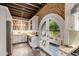 Bright kitchen featuring white cabinets, stainless steel appliances, granite countertops, and arched door to patio at 15 N Adgers Wharf, Charleston, SC 29401