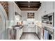 Stylish white kitchen with exposed brick, stainless steel appliances, granite countertops, and a farmhouse sink at 15 N Adgers Wharf, Charleston, SC 29401